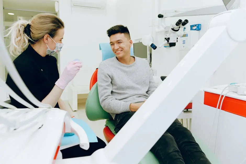 Dentist talking to a smiling patient in the examination chair